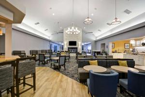 ein Restaurant mit Tischen und Stühlen und eine Bar in der Unterkunft Homewood Suites by Hilton Wilmington/Mayfaire, NC in Wilmington