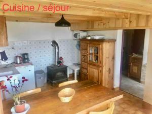 een keuken met een houten tafel en een fornuis bij Chalet accueillant pour des vacances reposantes in Jarrier