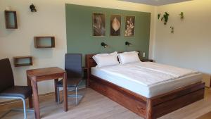 a bedroom with a bed and a table and a desk at Lillys Garden in Wutha-Farnroda