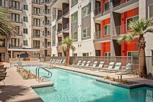 uma piscina exterior com cadeiras e palmeiras num edifício em Locale Midtown Phoenix em Phoenix