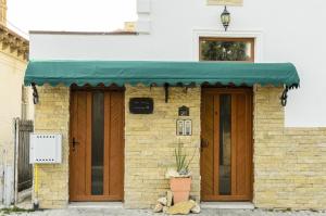 ein Backsteingebäude mit grüner Markise darauf in der Unterkunft Villa Casafina Serviced Apartments in Mangalia
