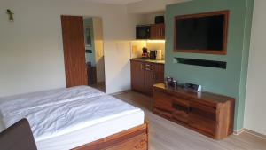 a bedroom with a bed and a flat screen tv at Lillys Garden in Wutha-Farnroda