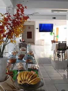 a buffet with plates of food on a table at Hotel Estrela Mares in Três Marias