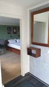 een slaapkamer met een bed en een spiegel bij Lillys Garden in Wutha-Farnroda