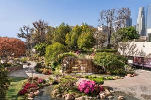 a garden with flowers and a waterfall in a city at Doubletree by Hilton Los Angeles Downtown in Los Angeles