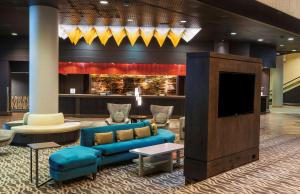 a lobby with a blue couch and a tv at Doubletree by Hilton Los Angeles Downtown in Los Angeles
