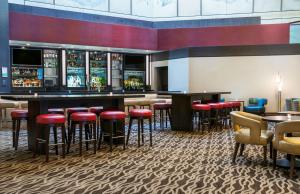 a bar in a restaurant with red stools at Doubletree by Hilton Los Angeles Downtown in Los Angeles