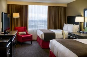 a hotel room with two beds and a red chair at Doubletree by Hilton Los Angeles Downtown in Los Angeles
