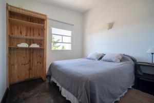 Un dormitorio con una cama grande y una ventana en Bahia Bustamante Lodge en Bahía Bustamante