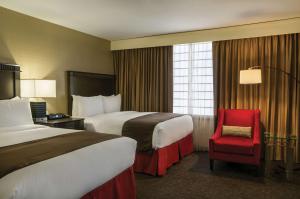 a hotel room with two beds and a red chair at Doubletree by Hilton Los Angeles Downtown in Los Angeles +37 photos