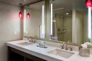 a bathroom with two sinks and a large mirror at Doubletree by Hilton Los Angeles Downtown in Los Angeles