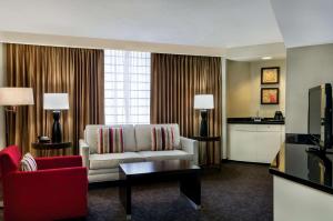 a living room with a white couch and a red chair at Doubletree by Hilton Los Angeles Downtown in Los Angeles