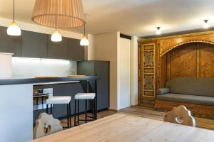 a kitchen with a bar and a couch in a room at Ciasa Buro - Ron in Moena