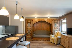 a living room with a couch and a kitchen at Ciasa Buro - Ron in Moena