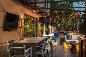 un restaurante con mesa, sillas y TV en Hilton Garden Inn Los Angeles / Hollywood en Los Ángeles