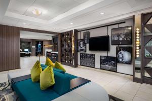 a living room with a blue couch and yellow pillows at Hilton Garden Inn Los Angeles / Hollywood in Los Angeles