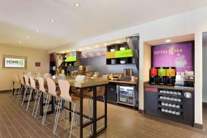 um restaurante com um bar com mesa e cadeiras em Home2 Suites by Hilton Midland em Midland