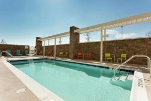 uma piscina num hotel com cadeiras e mesas em Home2 Suites by Hilton Midland em Midland
