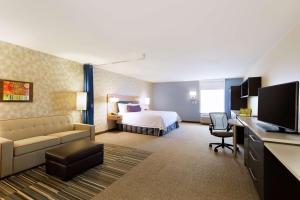 um quarto de hotel com uma cama e um sofá em Home2 Suites by Hilton Midland em Midland