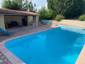 a large blue swimming pool with a gazebo at Gîtes de Lartigue in Anthé