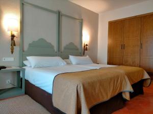 a bedroom with a large bed with white sheets at Parador de Benavente in Benavente