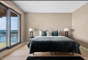 ein Schlafzimmer mit einem großen Bett und einem großen Fenster in der Unterkunft Moderne nydelig villa med Panorama Utsikt in Sandefjord