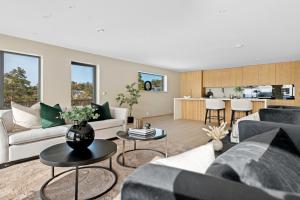 a living room with couches and tables and a kitchen at Moderne nydelig villa med Panorama Utsikt in Sandefjord