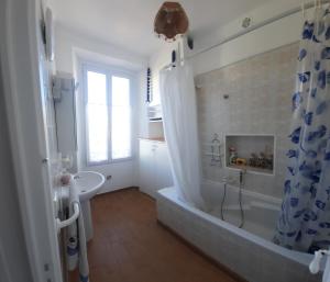 een badkamer met een bad en een douchegordijn bij GHIS Lotus in Cannes
