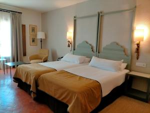 una camera con un grande letto in una camera d'albergo di Parador de Benavente a Benavente