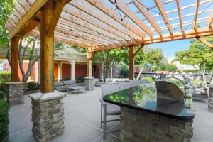 an outdoor kitchen with a wooden pergola at Homewood Suites by Hilton Southwind - Hacks Cross in Memphis