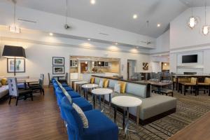 a restaurant with blue chairs and tables and a bar at Homewood Suites by Hilton Southwind - Hacks Cross in Memphis