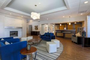 sala de estar con sofás azules y cocina en Homewood Suites by Hilton Southwind - Hacks Cross, en Memphis