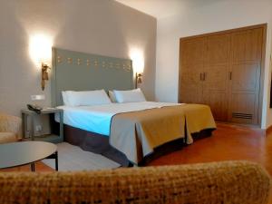 Habitación de hotel con cama grande y sofá en Parador de Benavente en Benavente
