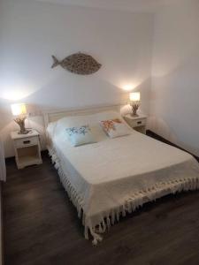 een slaapkamer met een bed met twee lampen aan beide zijden bij Cuana Precioso apartamento 2 minutos playa, parking gratuito, Roses centro in Roses