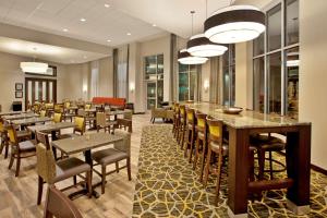 a restaurant with tables and chairs and a bar at Hampton Inn & Suites - Minneapolis/Downtown in Minneapolis