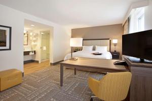 Dormitorio con cama, escritorio y TV en Hampton Inn & Suites - Minneapolis/Downtown, en Minneapolis