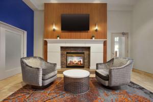 a living room with two chairs and a fireplace at Hilton Garden Inn New Orleans Convention Center in New Orleans