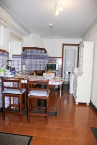 a kitchen with a table and chairs and a refrigerator at Casa do Largo - Açores in Ponta Delgada