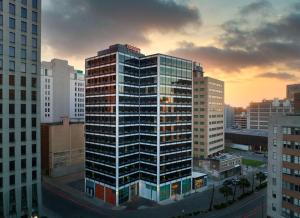um edifício alto numa cidade ao pôr do sol em Canopy by Hilton New Orleans Downtown em Nova Orleães