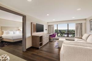 a hotel room with a bed and a couch at DoubleTree by Hilton New Orleans Airport in Kenner