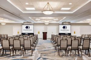 a room with rows of chairs in a room with two screens at DoubleTree by Hilton New Orleans Airport in Kenner +36 photos