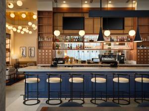 a bar in a restaurant with stools at Canopy by Hilton New Orleans Downtown in New Orleans