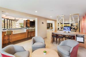 a kitchen and living room with a bar and chairs at Doubletree By Hilton Pomona in Pomona