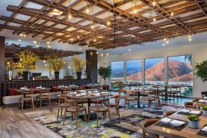un restaurante con mesas, sillas y ventanas grandes en Doubletree By Hilton Pomona, en Pomona