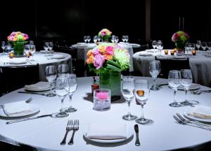 um conjunto de mesa para um banquete com copos e flores em Hilton New York Fashion District em Nova York