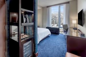 a hotel room with a bed and a large window at Hilton New York Fashion District in New York