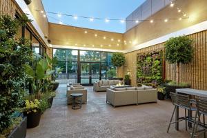 a lobby with couches and plants in a building at Hilton Pasadena in Pasadena