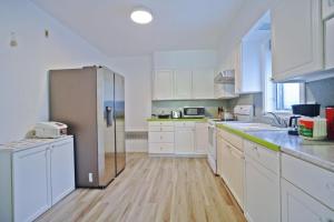 cocina con armarios blancos y nevera de acero inoxidable en Tranquil cozy Apartment in charming area en Albany