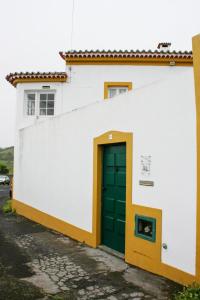 un edificio bianco con una porta verde sul lato di Casa do Largo - Açores a Ponta Delgada