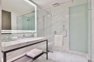 a white bathroom with a sink and a shower at Le Méridien Amritsar in Amritsar